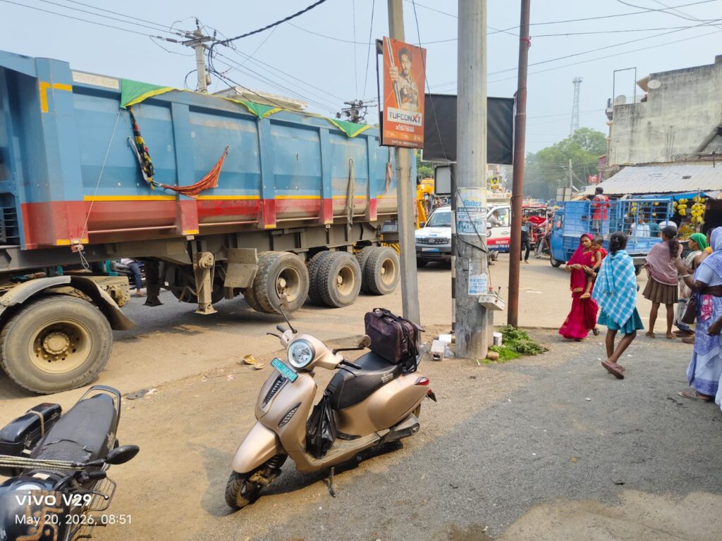 Vehicle parking on the road due to lack of permanent bus stand.