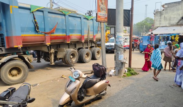 Vehicle parking on the road due to lack of permanent bus stand.